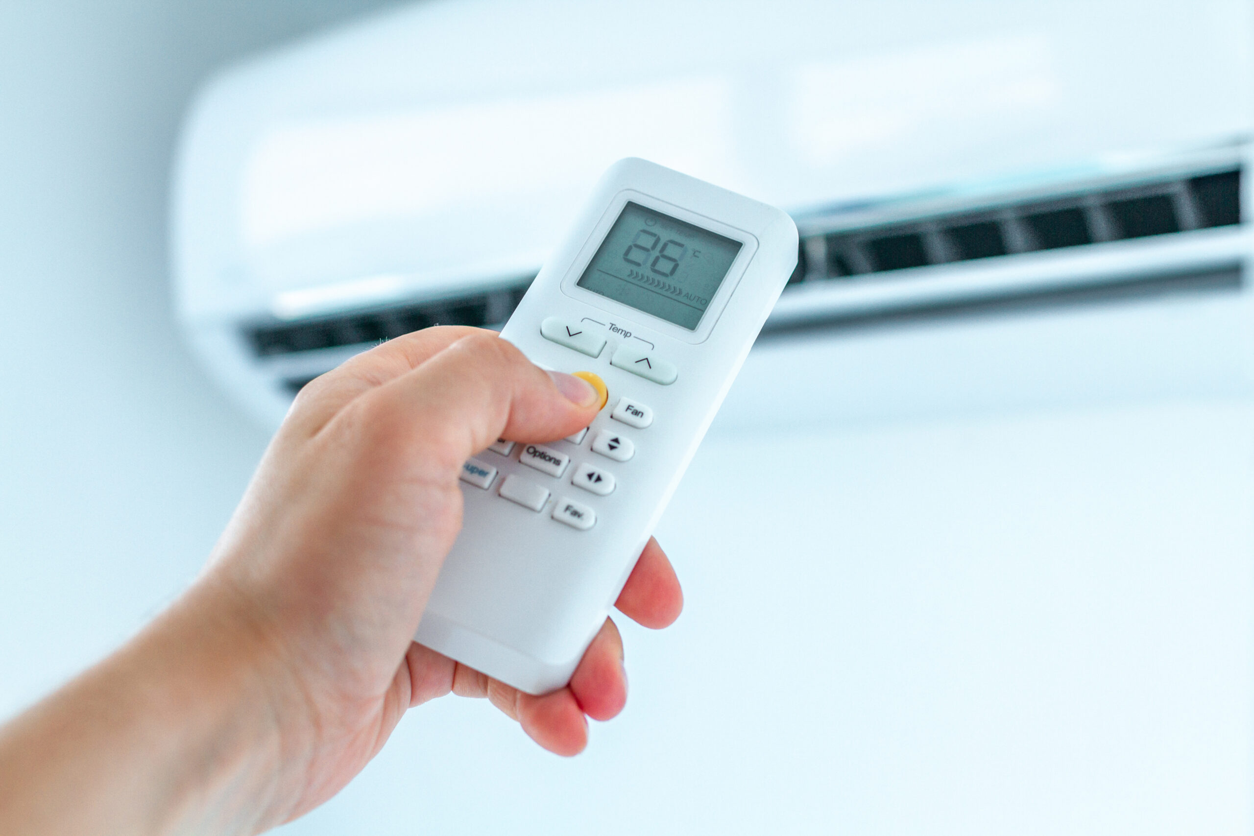 Réglage de la température du climatiseur avec télécommande dans la pièce de la maison.